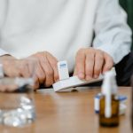 A senior adult preparing medicine doses at home, emphasizing healthcare and telehealth solutions.